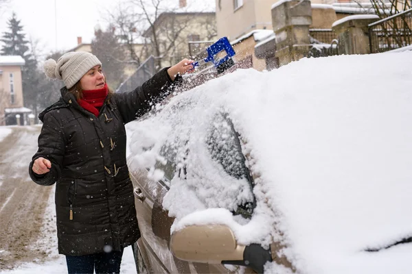 Žena čistí sněhu auto — Stock fotografie