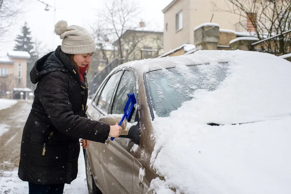 Γυναίκα καθαρίζει χιόνι αυτοκίνητο — Φωτογραφία Αρχείου