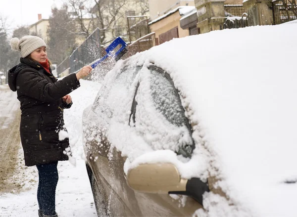 Žena čistí sněhu auto — Stock fotografie