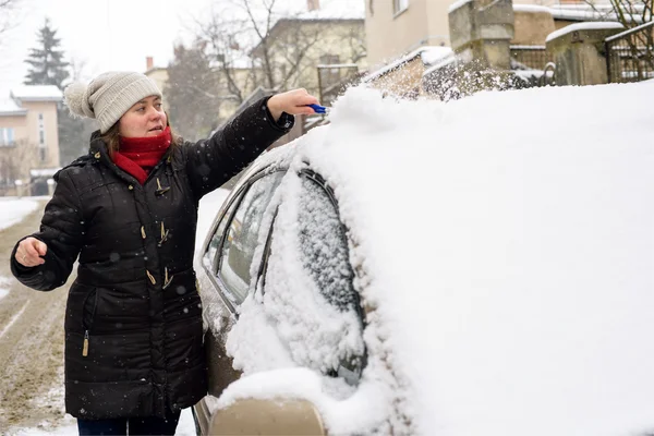 Žena čistí sněhu auto — Stock fotografie