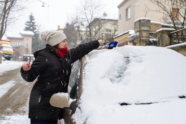 Žena čistí sněhu auto — Stock fotografie