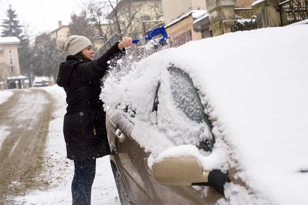 Žena čistí sněhu auto — Stock fotografie