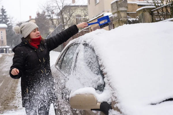 Žena čistí sněhu auto — Stock fotografie