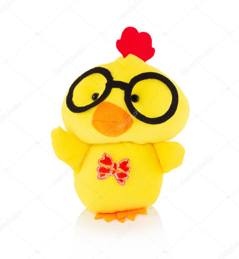 Yellow chicken plushie doll isolated on white background with shadow reflection. Plush stuffed puppet on white backdrop. Fluffy rooster toy with glasses for children. Cute furry plaything for kids.
