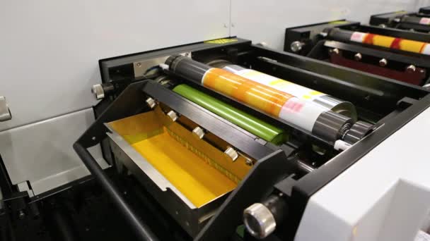 Flexography printing process on in-line press machine. Video of photopolymer plate stuck on printing cylinder, substrate is sandwiched between the plate and the impression cylinder to transfer the ink — Stock Video