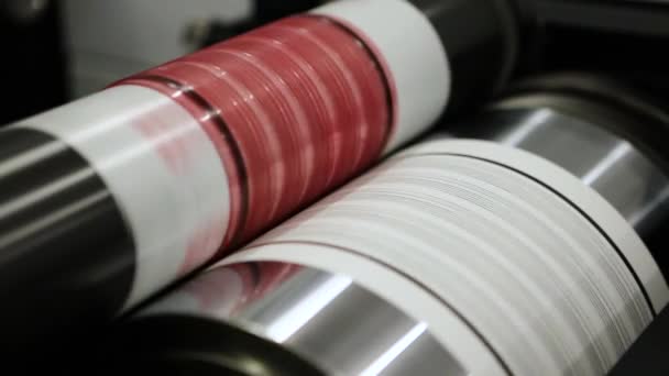 Flexography printing process on in-line press machine. Video of photopolymer plate stuck on printing cylinder, substrate is sandwiched between the plate and the impression cylinder to transfer the ink — Stock Video