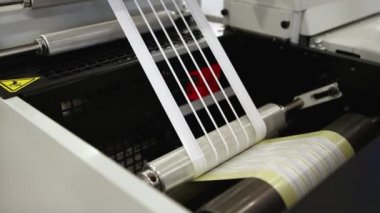 Flexo baskı makinesindeki etiket imalatının yakın çekim videosu. Matrix atığı ya da baskı endüstrisindeki esnek baskı malzemelerinin çıkarılması.