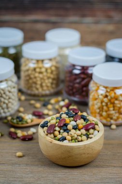 Soya fasulyesi, fasulye, fasulye, kırmızı fasulye, ahşap bir masada kurutulmuş mısır gibi çeşitli tahıllar..