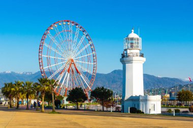 Batumi, Gürcistan - 13 Nisan 2020 - Seddin yakınındaki popüler turizm merkezi - Dönme dolap ve Deniz Feneri.