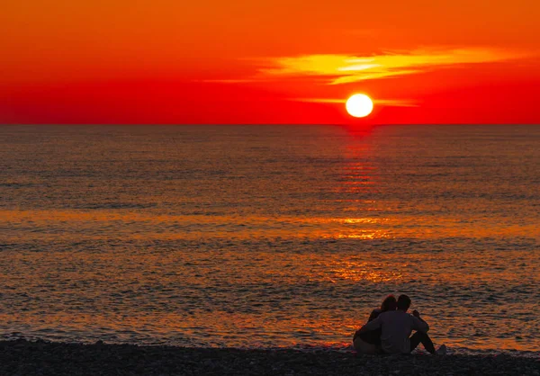夕日を背景に海岸で恋をしているカップル — ストック写真