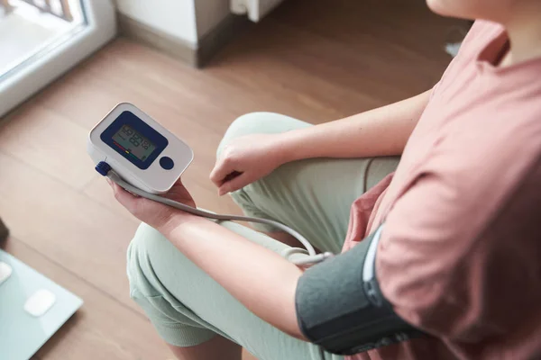 Selective focus girl is taking care for health with hearth beat monitor and blood pressure and heart rate monitor with digital pressure gauge. Health care and Medical concept. The topic of high blood pressure is hypertension disease. Close-up macro y