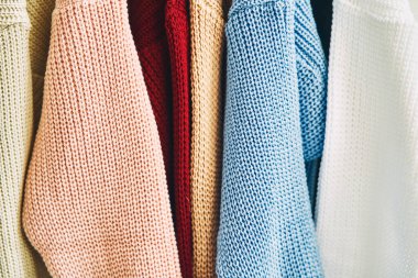 Askılarda çok renkli kadın yünlü kazakları. Moda mağazasında indirim var. Yüksek kalite fotoğraf