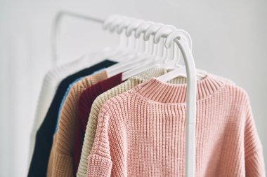 Askılarda çok renkli kadın yünlü kazakları. Moda mağazasında indirim var. Yüksek kalite fotoğraf