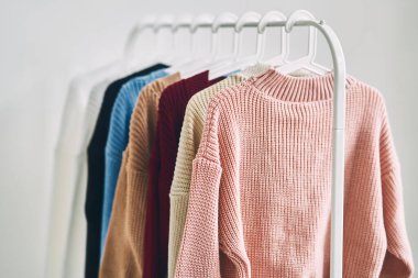 Askılarda çok renkli kadın yünlü kazakları. Moda mağazasında indirim var. Yüksek kalite fotoğraf