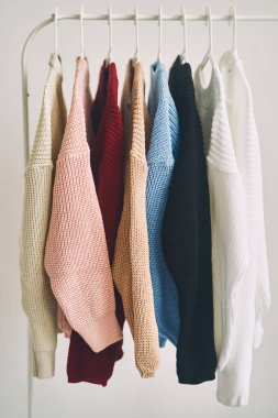 Askılarda çok renkli kadın yünlü kazakları. Moda mağazasında indirim var. Yüksek kalite fotoğraf