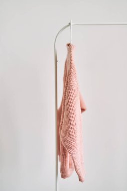 Beyaz arka planda askıda asılı yün bir kazak. Sıcak giysi satışı. Konsept - bir giyim mağazasında her şey satılır..