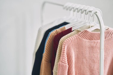 Askılarda çok renkli kadın yünlü kazakları. Moda mağazasında indirim var. Yüksek kalite fotoğraf