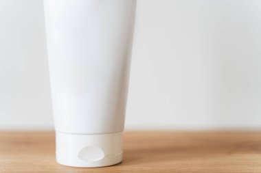 Beyaz tüp krem, ahşap bir masanın üzerinde..