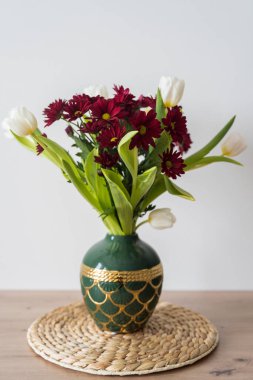 Beyaz arka planda vazoda bir buket lale ve kasımpatı. Yüksek kaliteli fotoğraf.