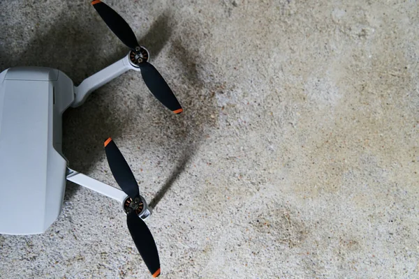 Piccolo quadricottero grigio su sfondo grigio. Quadrocopter primo piano. — Foto Stock