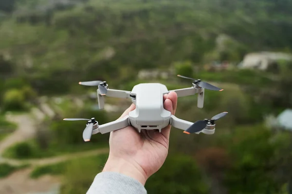 Piccolo quadricottero compatto moderno in una mano di mans. Lancio di un drone dalla tua mano — Foto Stock