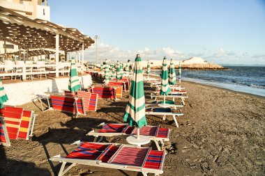 Pandemik koronavirüs sırasında kumsalda boş güneş yatakları. Arnavutluk 'un Durres kentinde terk edilmiş plaj