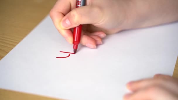Νεαρή γυναίκα γράφει τη λέξη ΝΑΙ σε κόκκινο μαρκαδόρο σε λευκό χαρτί — Αρχείο Βίντεο