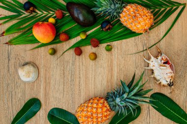 Düz, üst görünüm, kahverengi arka planda egzotik meyvelerin karışımı: ananas, mango, mangosteen, lychee, narenciye meyvesi