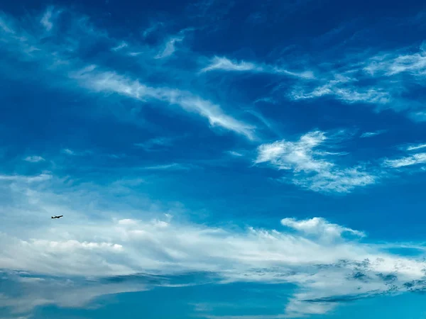 Concept de voyage aérien. Ciel bleu avec des nuages blancs. Petite silhouette de l'avion prenant de l'altitude — Photo