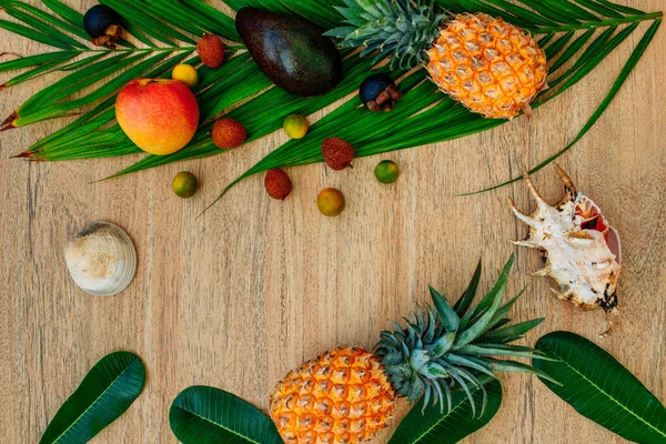 Flat lay, top view, Mix of Exotic fruits on a brown background: pineapples, mangoes, mangosteen, lychee, citrus fruits