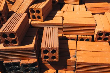 İçi boş kırmızı tuğlalar yığılmış, inşaatta ya da satışta kullanılmaya hazır. İnşaat malzemeleri. Düzgün katlanmış tuğla, reklam için fotoğraf. Yer kopyala