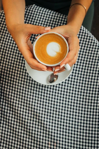 Flickor händer hålla en kopp aromatisk cappuccino Royaltyfria Stockbilder