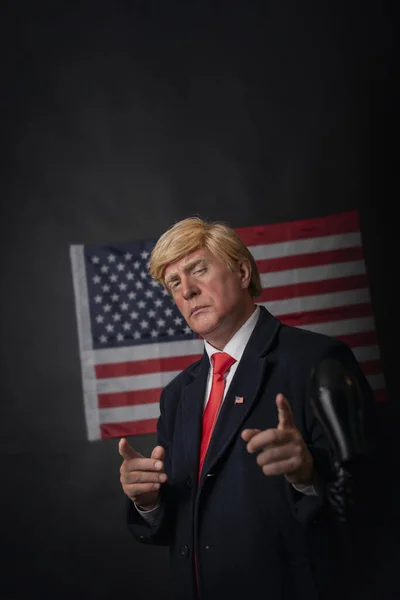 American presidential elections 2020 against a dark background with an American flag, a triumphant mature man, character, actor, republican who gestures desperately and emotionally in a debate.