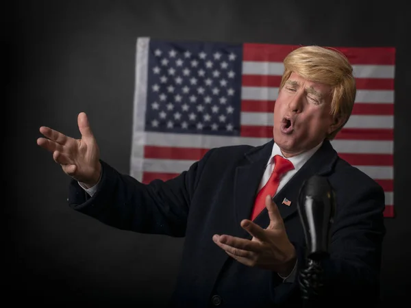 アメリカの大統領選挙2020アメリカの国旗 意気揚々と成熟した男性 キャラクター 共和党の暗い背景を背景に 必死にそして感情的に議論の中でジェスチャー — ストック写真