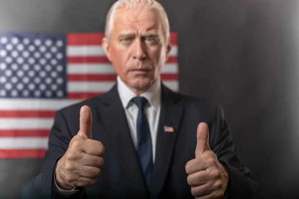 American presidential elections 2020 on a dark background with the American flag, a mature gray-haired man, character, actor, republican who emotionally gestures and shows thumbs up in debates.