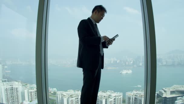 Aziatische share Broker met mini tablet — Stockvideo