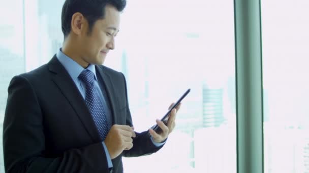 Hombre de negocios asiático utilizando la tableta inalámbrica — Vídeos de Stock