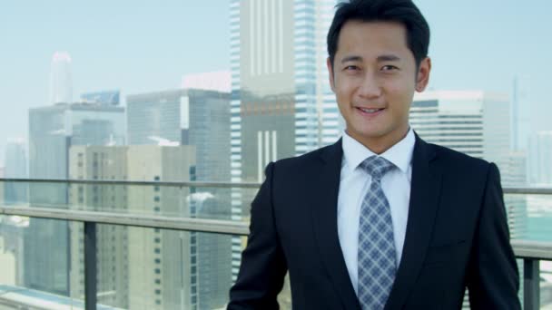 Joven asiático hombre de negocios de pie en la azotea — Vídeo de stock