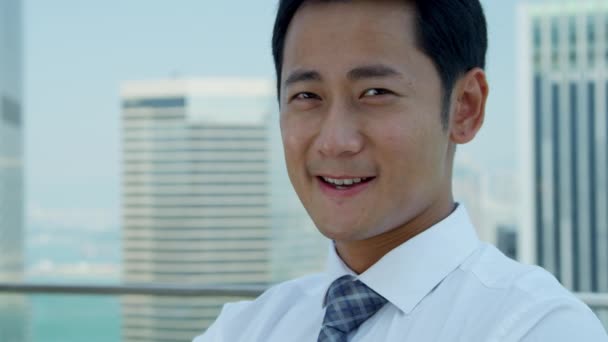 Joven asiático hombre de negocios de pie en la azotea — Vídeos de Stock