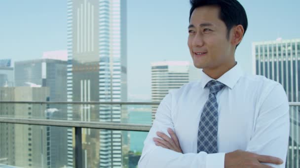 Joven asiático hombre de negocios de pie en la azotea — Vídeo de stock
