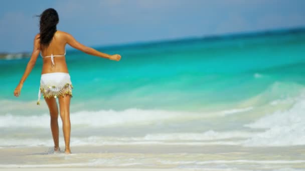 ビキニは海の浅瀬で水しぶきを着ている少女 — ストック動画