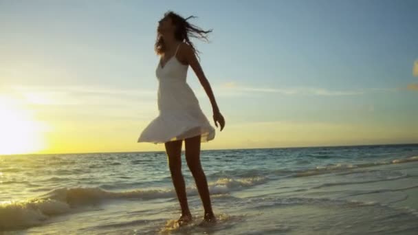 Chica salpicando en el océano poco profundo al atardecer — Vídeos de Stock