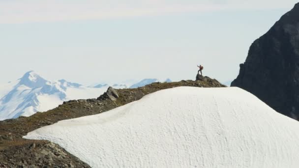 Escalador de montaña disfrutando del éxito en pico alto — Vídeos de Stock