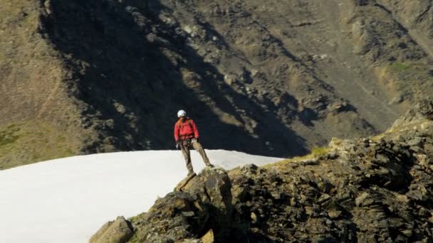 Escalador de montaña disfrutando del éxito en pico alto — Vídeos de Stock