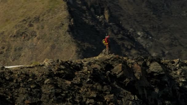 Escalador de montaña disfrutando del éxito en pico alto — Vídeo de stock