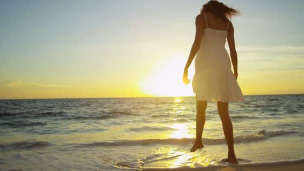 Girl splashing in ocean shallows at sunset — Stock Video