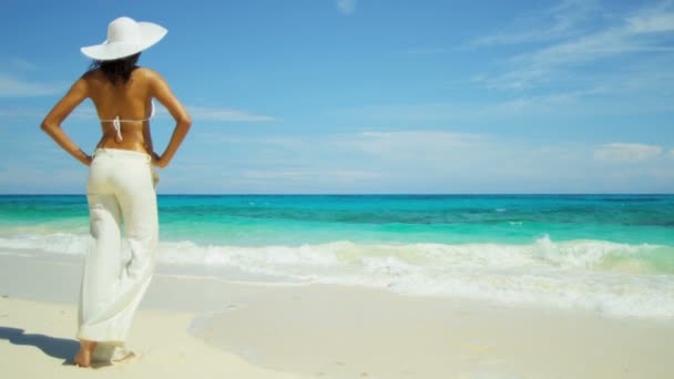 Дівчина в білих штанях насолоджується пляжним відпочинком — стокове відео