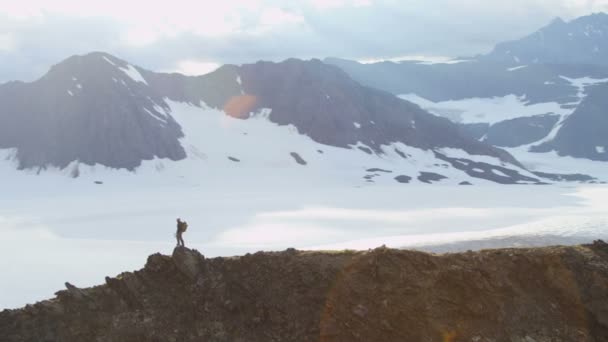 Escalador de montaña disfrutando del éxito en pico alto — Vídeo de stock