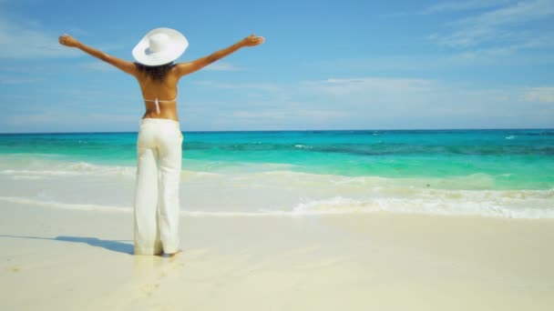 Девушка в белых брюках наслаждается пляжным отдыхом — стоковое видео