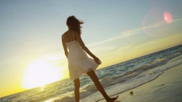 Lány fröccsenő óceán sekély naplementekor — Stock videók